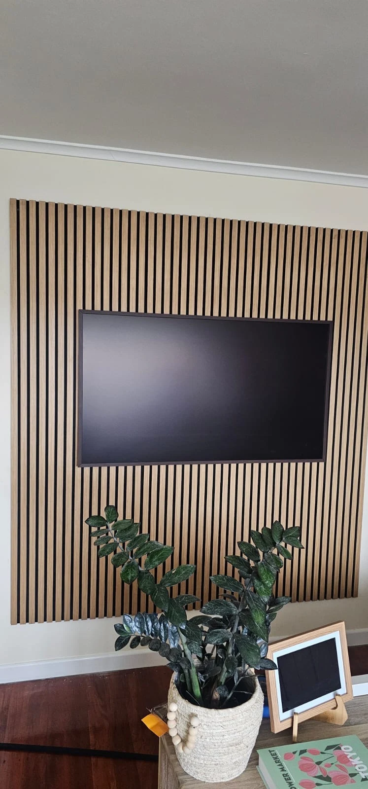 Wall-mounted television with timber slat feature panelling.