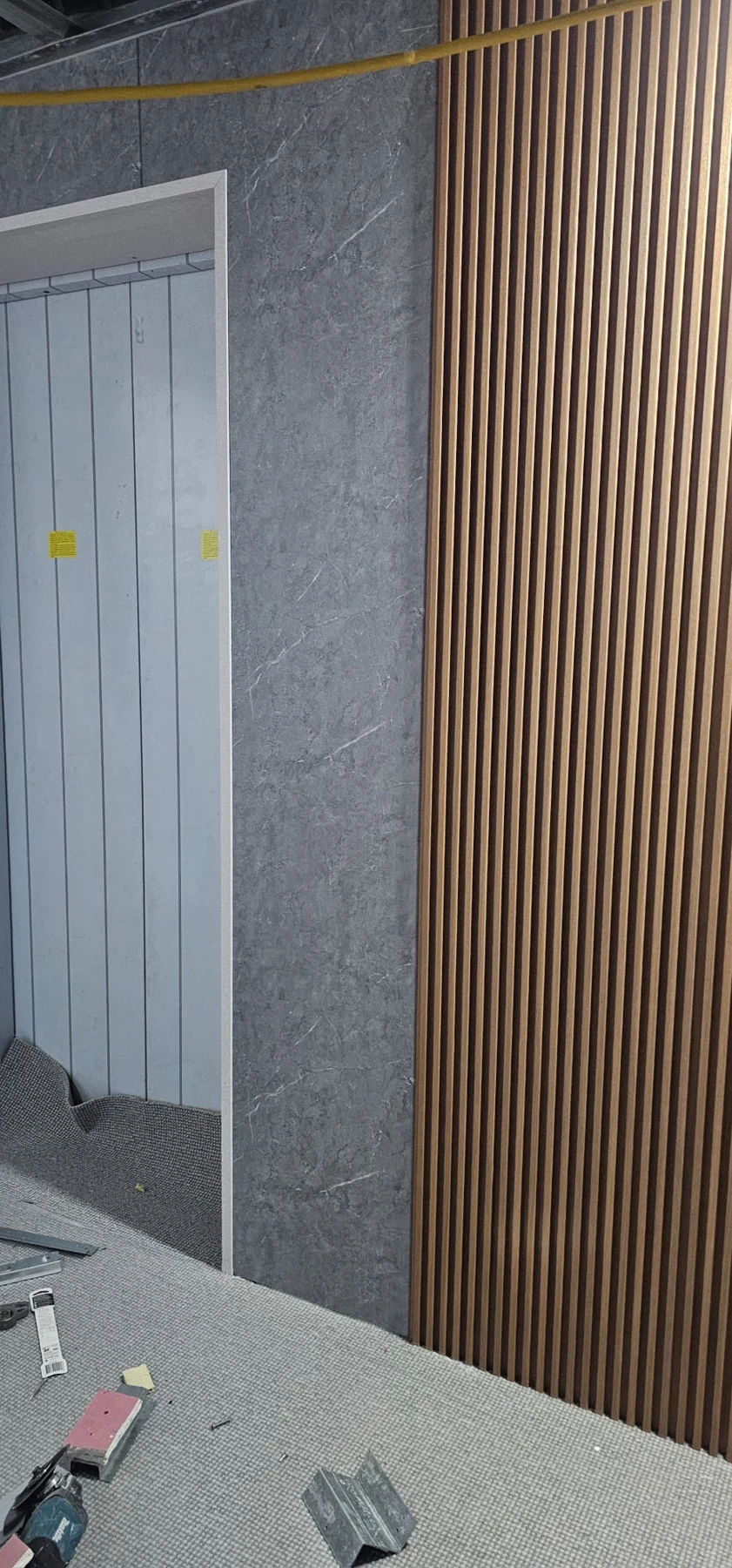Timber slats and stone-look wall finishes during installation.